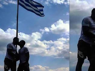 Φωτογραφία για Αξιωματικός της ελληνικής αστυνομίας φιλιέται με «μετανάστη» μπροστά στην Ελληνική σημαία