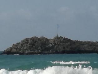 Φωτογραφία για Κολύμπησε για να αντικαταστήσει την κουρελιασμένη σημαία σε νησίδα