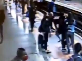 Φωτογραφία για Η τρομακτική στιγμή που άγνωστος προσπαθεί να ρίξει γυναίκα στις ράγες και το μετρό έρχεται.