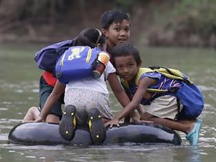 Φωτογραφία για Περνούν καθημερινά το ποτάμι πάνω σε σαμπρέλα για να πάνε στο σχολείο