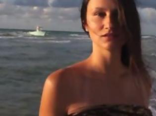 Φωτογραφία για Μοντέλο γυρίζει βίντεο στην παραλία ενώ από πίσω περνούν μετανάστες